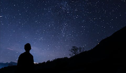 Einsamer wanderer vor spektakulärem Sternenhimmel